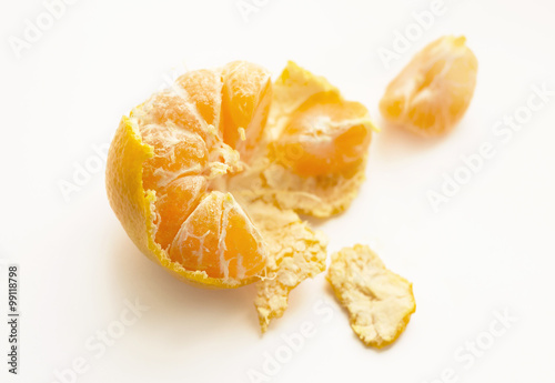 Mandarin fruit on a white background, slices of mandarin and rind, insufficiently treated mandarin photo