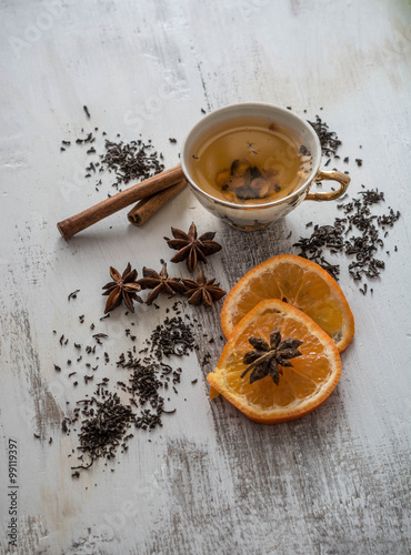 Tea, dried cinnamon,orange and anise on wooden background
