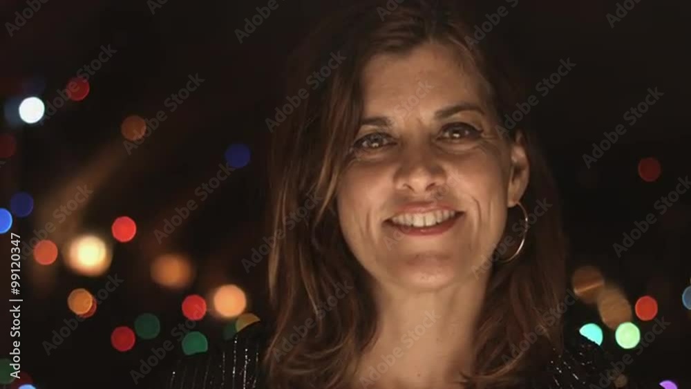 Smiling woman in night time setting raises an eyebrow. Close up. Smiling woman in night time setting raises an eyebrow. Close up.