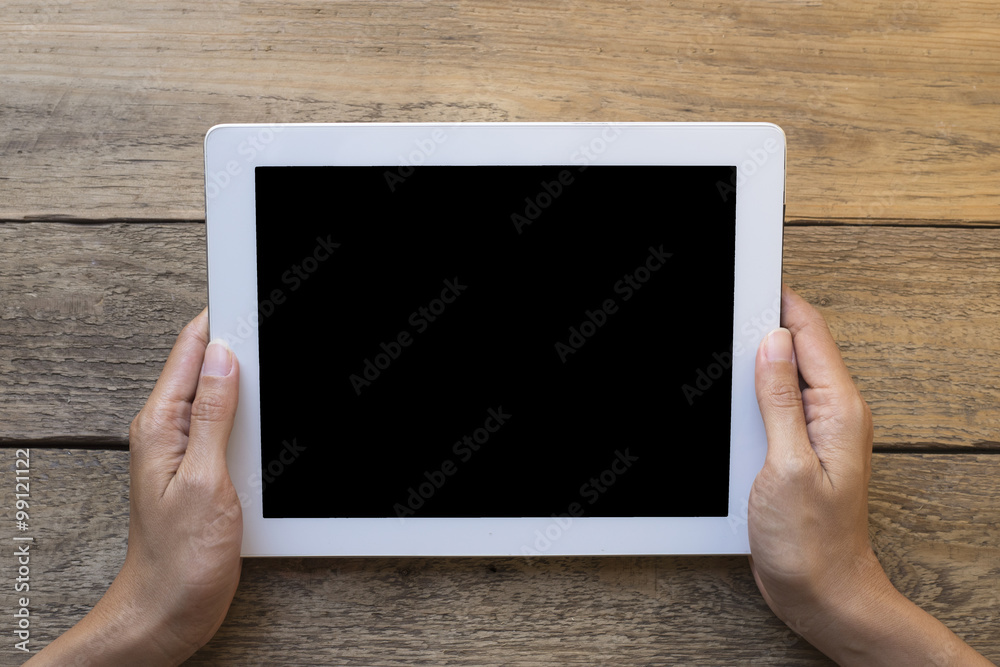 woman hand hold tablet over vintage wood background