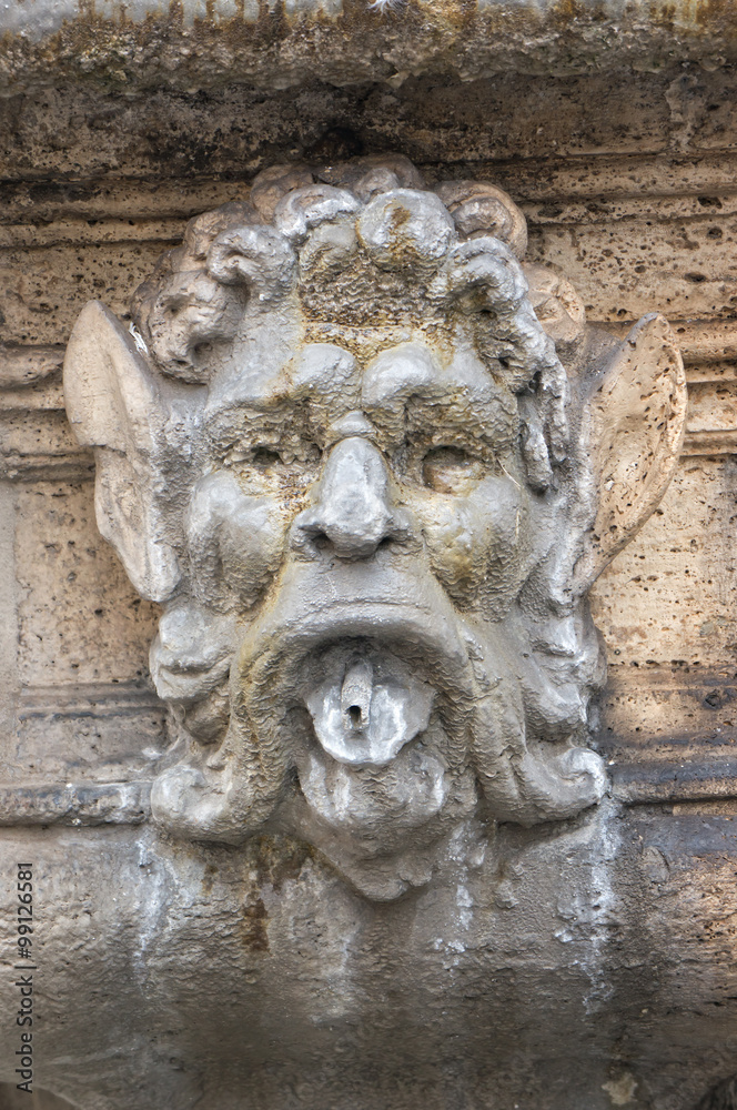 Mask decoration on a fountain in Rome Italy