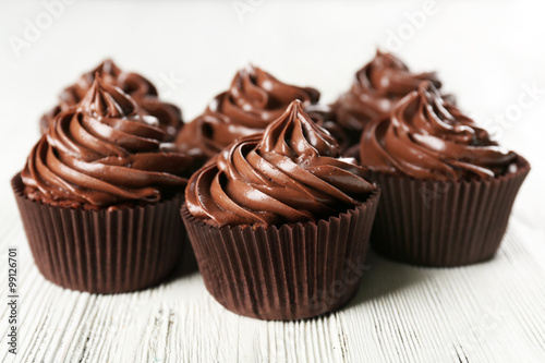 Chocolate cupcakes on light wooden background