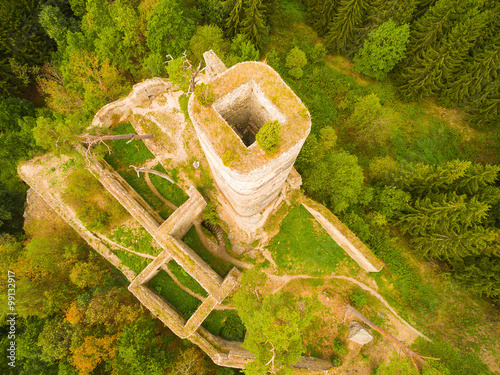 Aerial view of ancient ruins (gothic castle Gutstejn) in a deep forest. Discovery landmarks from drone. Czech Republic, Europe. photo