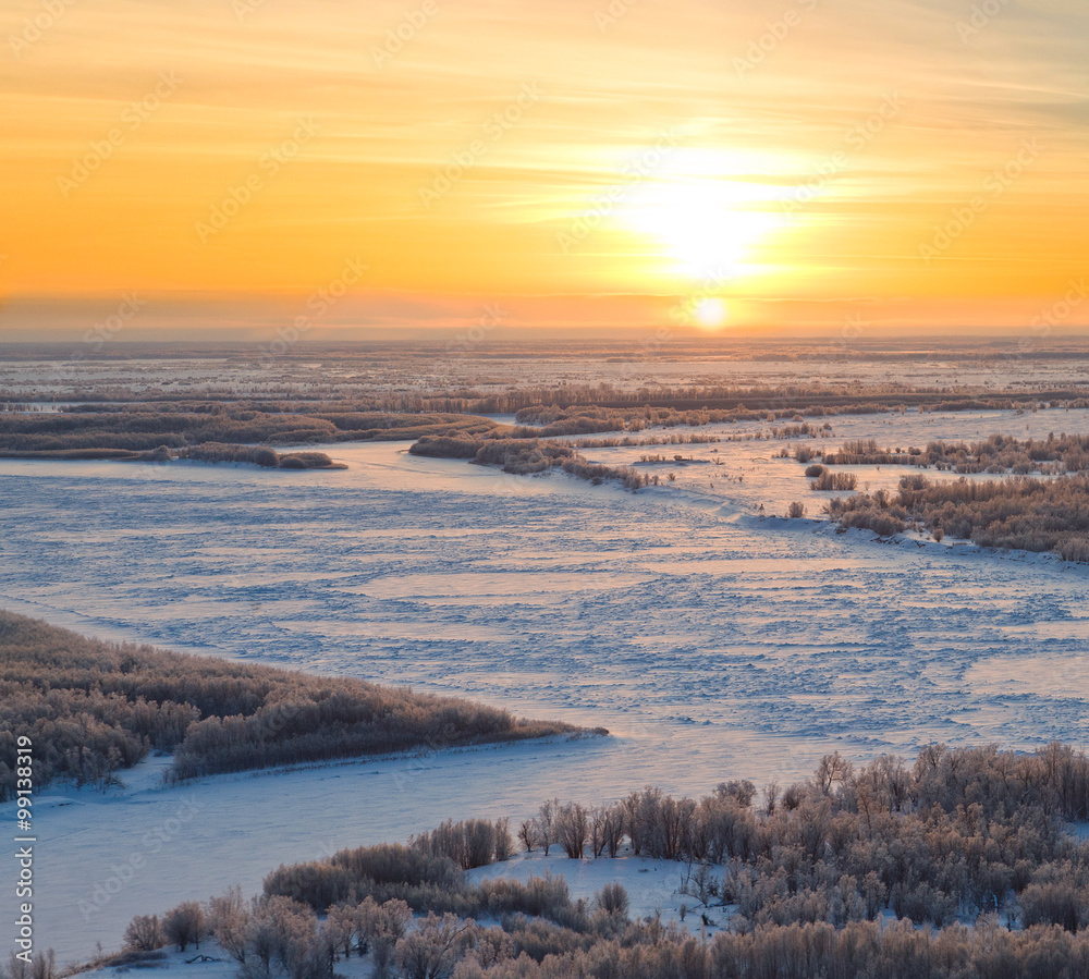 Forest river during cold winter sundown, top view