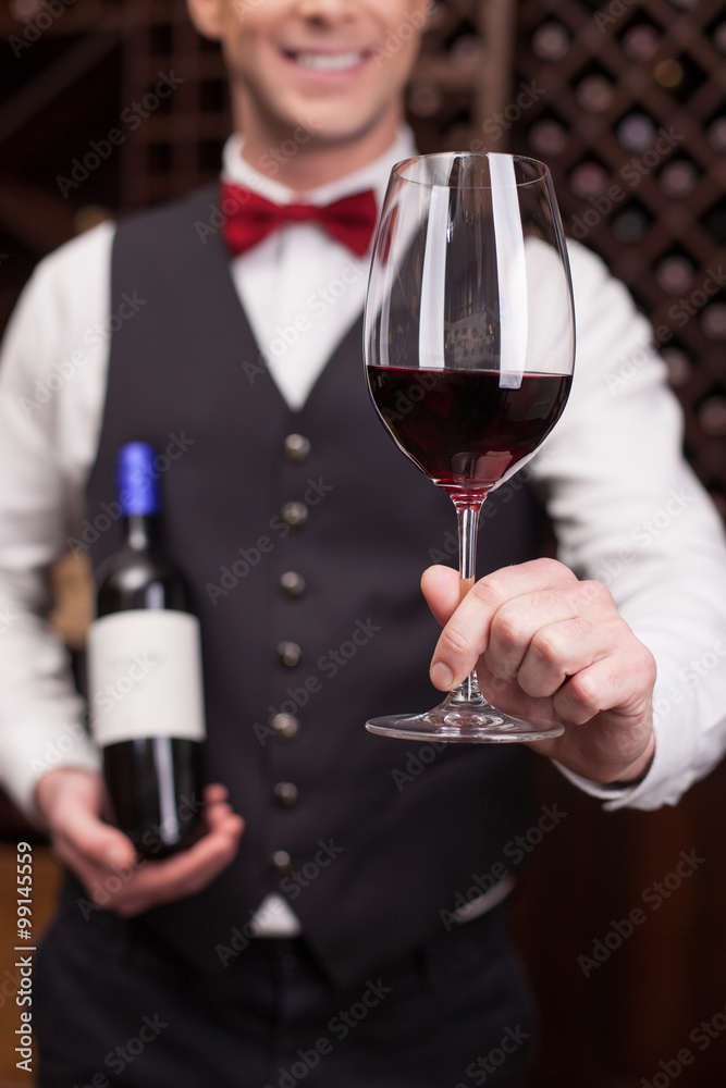 Cheerful young sommelier is serving a customer Cheerful young sommelier is serving a customer