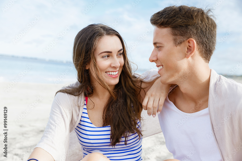 Romantic young couple sitting on the beach Romantic young couple sitting on the beach