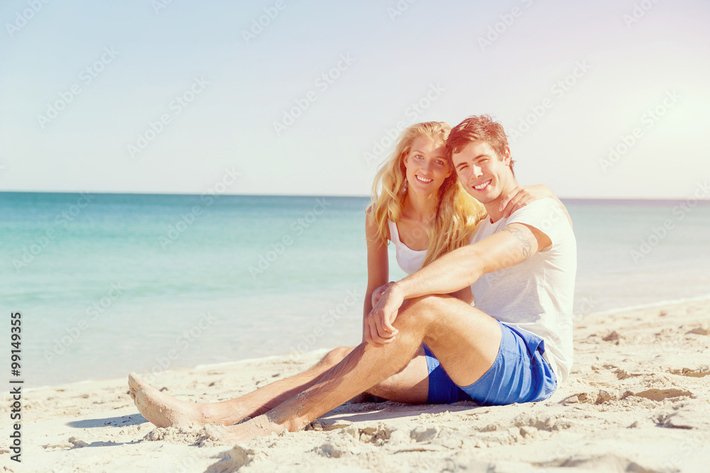 Romantic young couple sitting on the beach Romantic young couple sitting on the beach