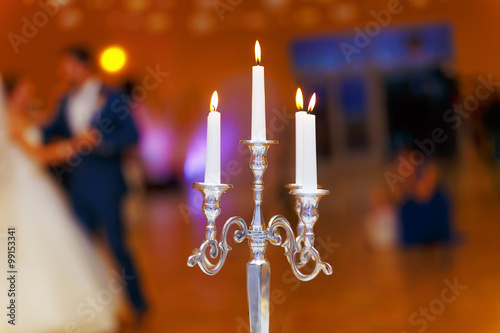 wedding decorative candle holder and dancing bride and groom on background. wedding concept.