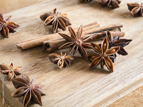 Star anise and cinnamon sticks on wooden chopping block