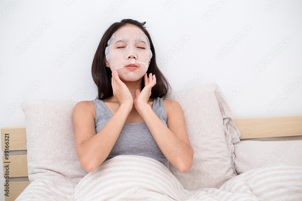 Young asian woman hand touch on her face with facial mask Young asian woman hand touch on her face with facial mask