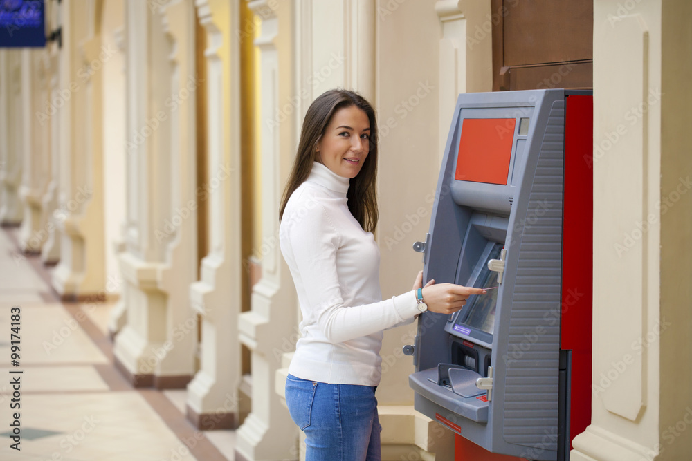 Young woman withdrawing money from credit card at ATM Young woman withdrawing money from credit card at ATM