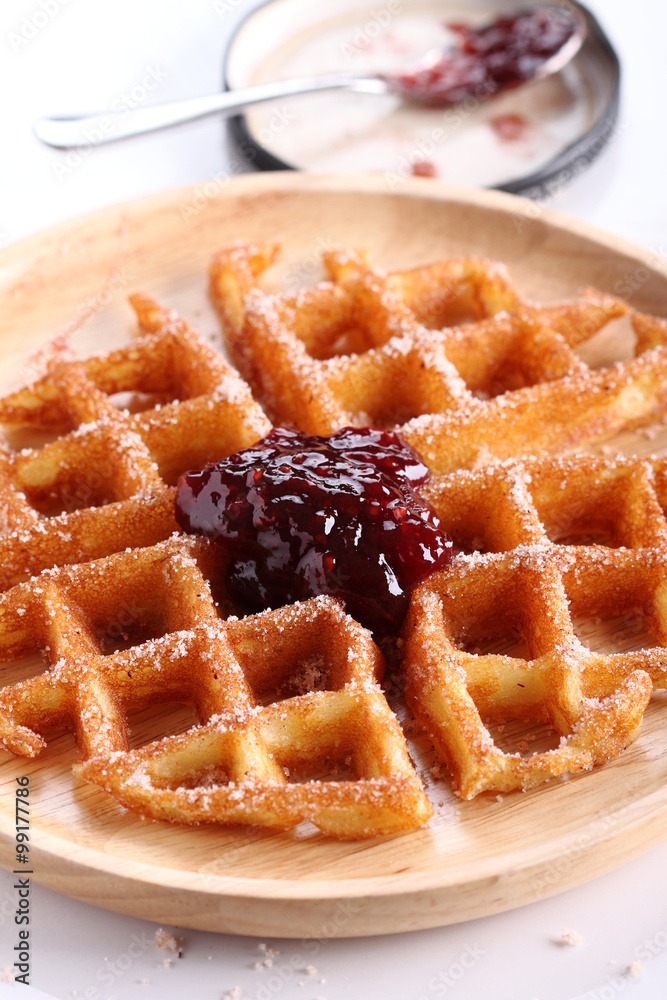 waffles with raspberry jelly on wooden plate. waffles with raspberry jelly on wooden plate.