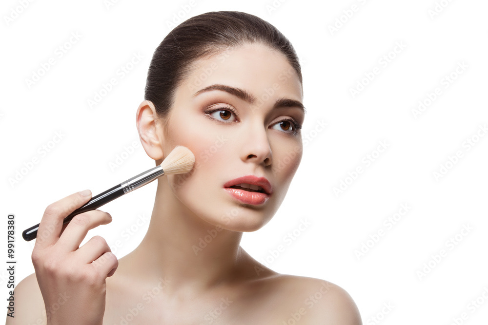 Beautiful girl applying blush with brush