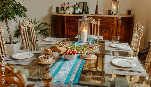 Ready to eat tomatoes with cheese , snails and bread on a table in a beautiful home interior