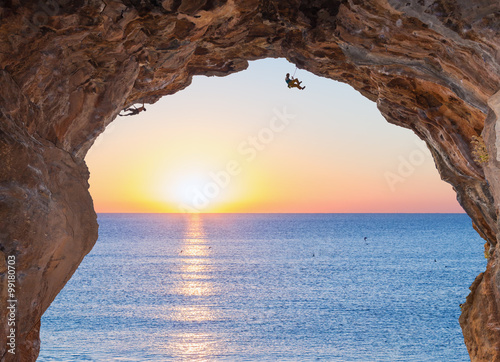 Deep high Cave on Seafront and extreme Climbers on Sunrise