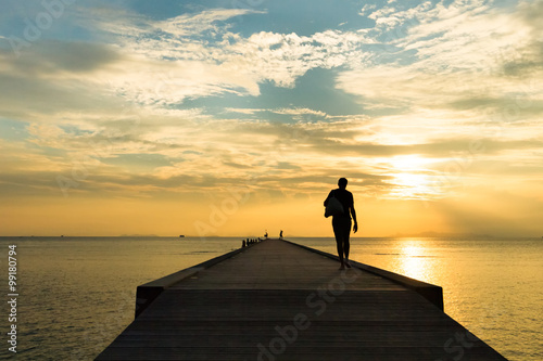 Woman walking on the pier at sunset on a tropical island. Koh Samui, Thailand