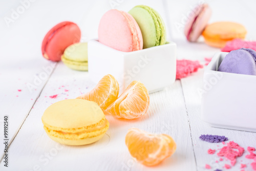 French Macaroons With Tangerine Slices On Wood Table