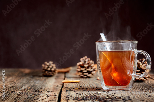 Steaming tea and honey on a wooden table