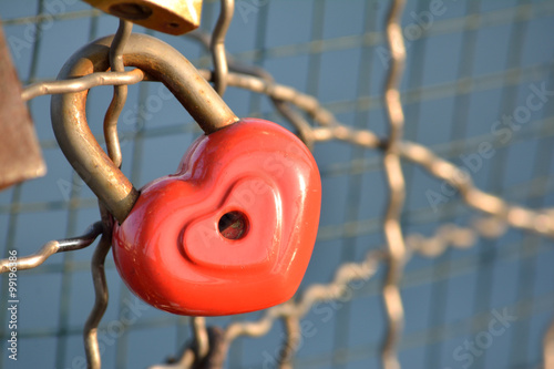 Padlock with heart sign hung on the bridge of love 