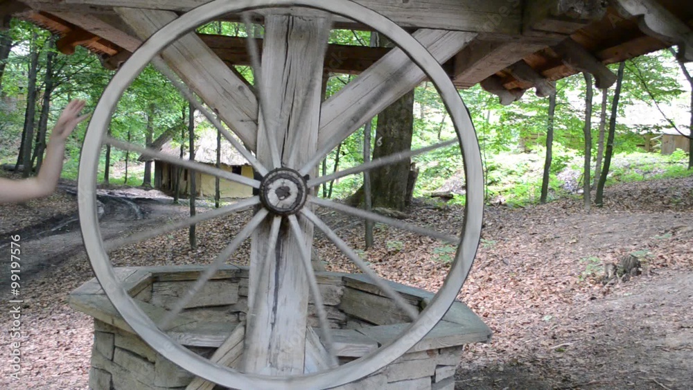 The wheel turns and the bucket with water rises The wheel turns and the bucket with water rises
