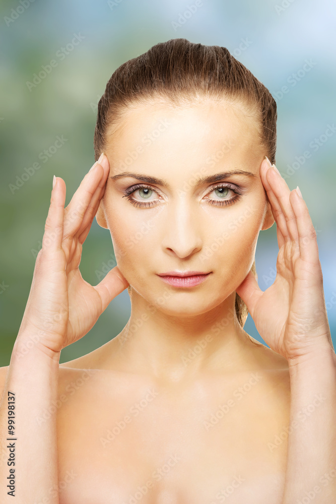 Spa woman with make up touching her face.