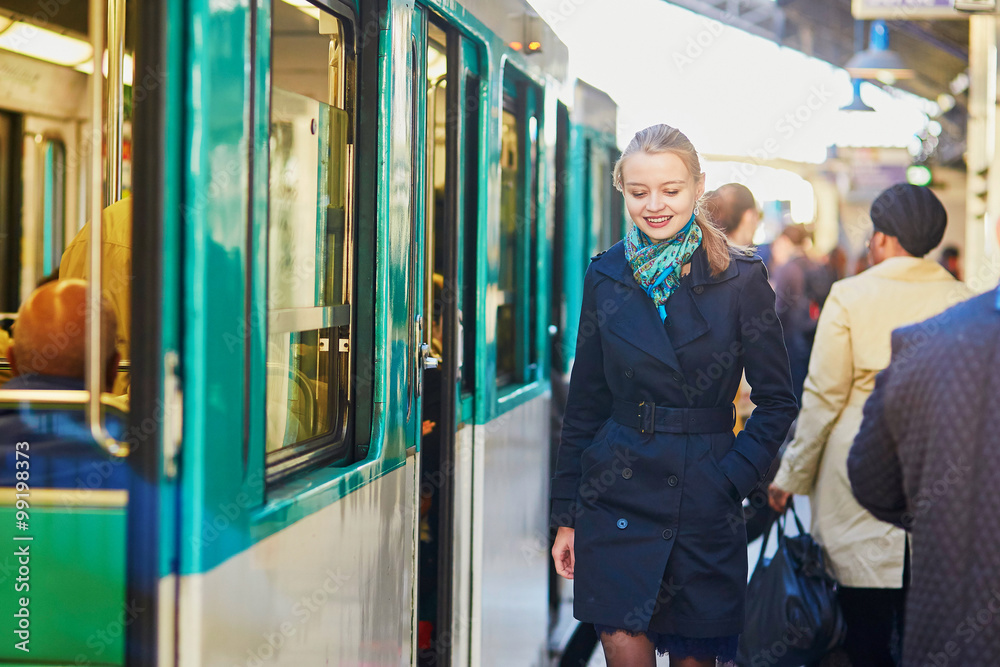 Fototapeta premium Woman waiting for a train on the platform of Parisian underground