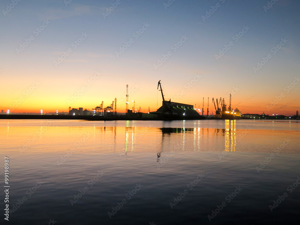 The shape of the crane and docks in the port at sunset