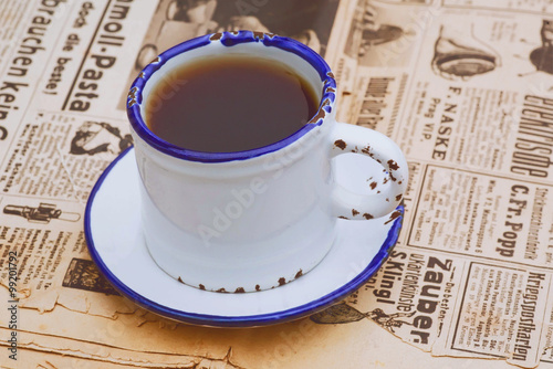 Vintage still life with coffee cup on the old newspaper