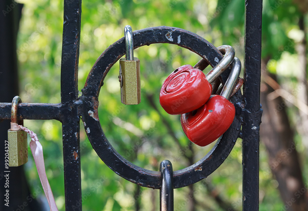 Red heart-shaped locks are hanging on the bridge lovers Red heart-shaped locks are hanging on the bridge lovers