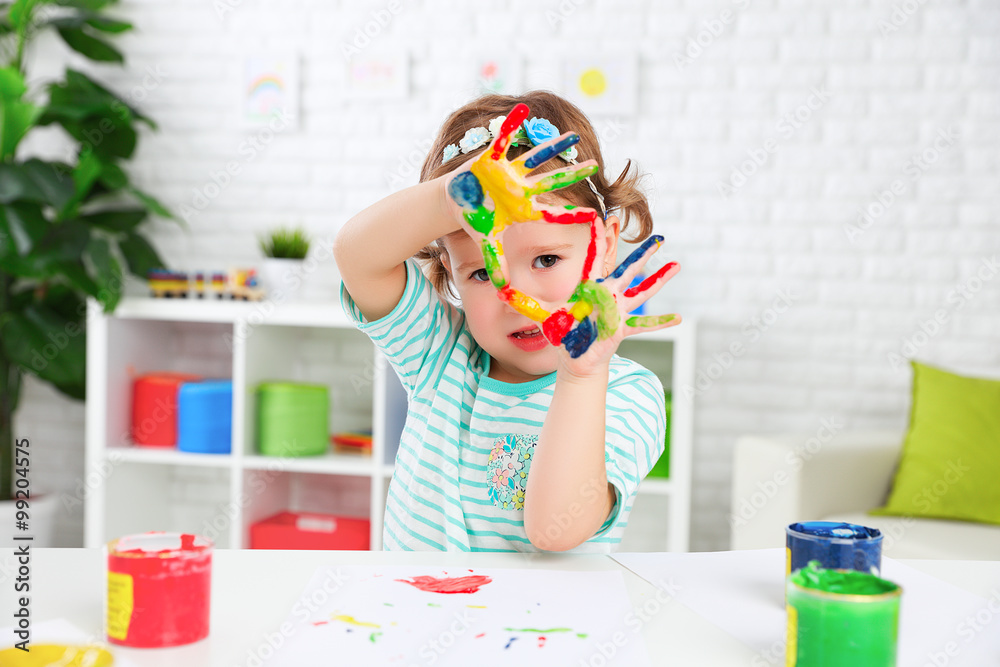 Obraz premium hands in colored paint happy child girl