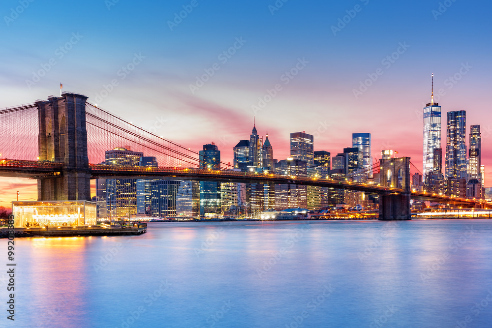 Brooklyn Bridge and the Lower Manhattan skyline under a purple sunset