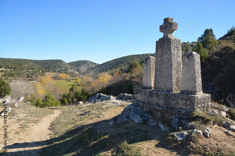 cruz de piedra en un camino de montaña