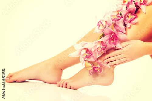 Fototapeta Naklejka Na Ścianę i Meble -  Woman legs with pink flowers.
