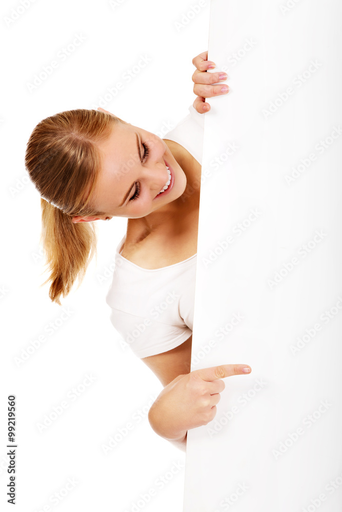 Smiling young woman pointing for empty banner Smiling young woman pointing for empty banner