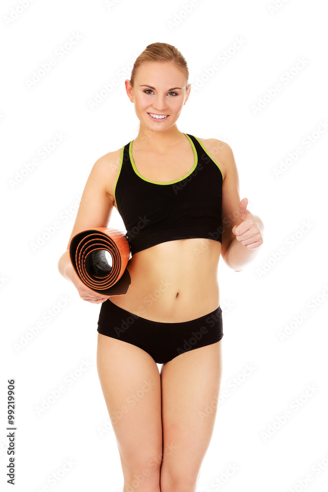 Woman ready for workout with yoga mats and thumb up Woman ready for workout with yoga mats and thumb up