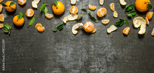 Fresh tangerines with leaves . On stone background.