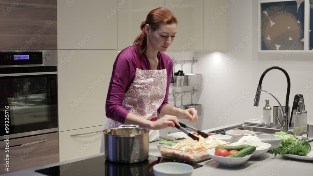 Young woman in kitchen preparing stuffed cabbage Young woman in kitchen preparing stuffed cabbage