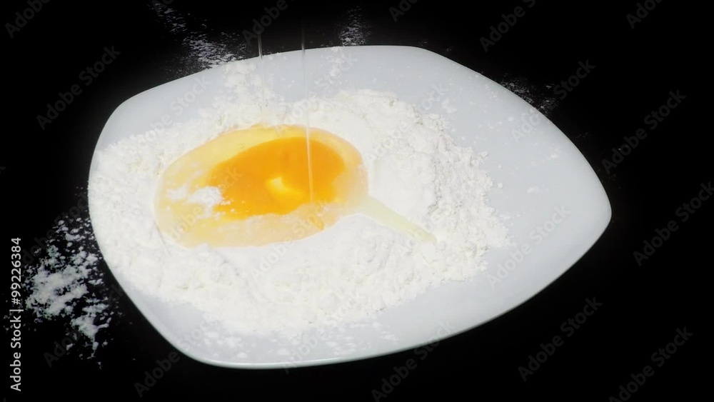 Mixing eggs on white flour. Slow motion Mixing eggs on white flour. Slow motion