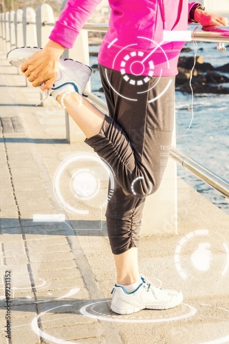 Composite image of sporty woman stretching leg at promenade