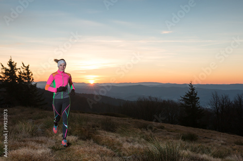 young woman running in the morning on the mountains with sunrise  © lukasx