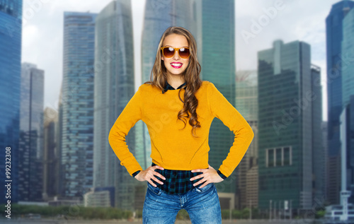 happy young woman or teen girl in shades over city © Syda Productions