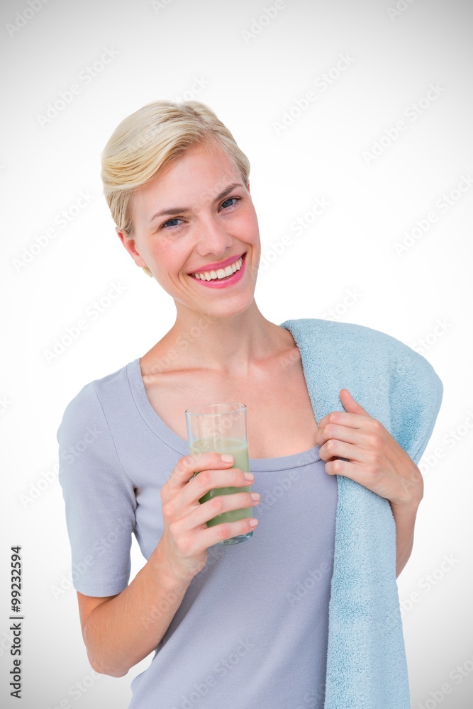 Composite image of fit woman holding healthy juice and towel Composite image of fit woman holding healthy juice and towel