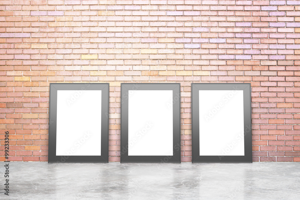 Blank white picture frames in empty loft room with concrete floo Blank white picture frames in empty loft room with concrete floo