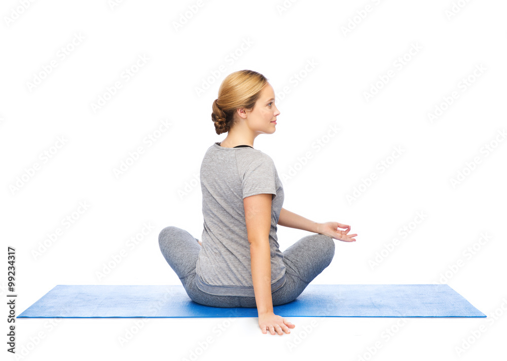 woman making yoga in twist pose on mat woman making yoga in twist pose on mat