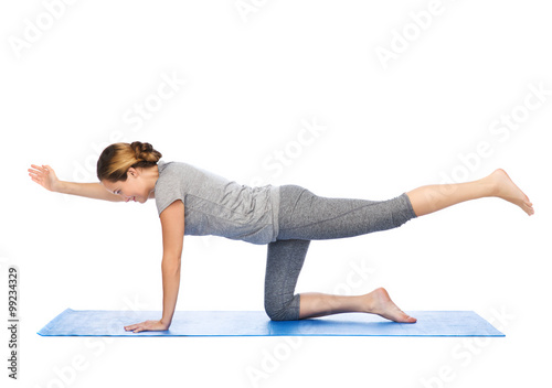 woman making yoga in balancing table pose on mat photo