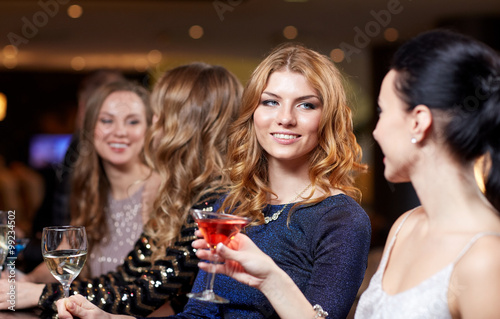 happy women with drinks at night club