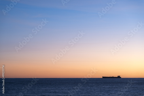 Silhouette  of cargo ship on the horizon