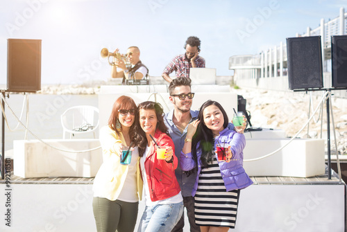 Group of people is dancing during a beach party - people and lifestyle concept