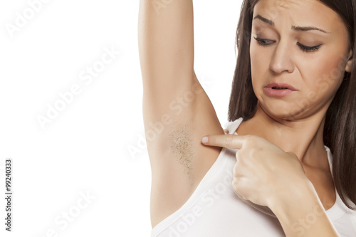 young woman shows her unshaved armpit 