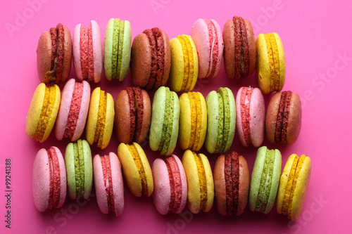 Sweet and colorful french macaroons on pink background